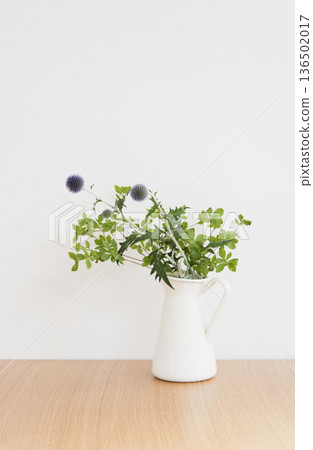 White vase and plant on a table White vase and plant on a table 136502017