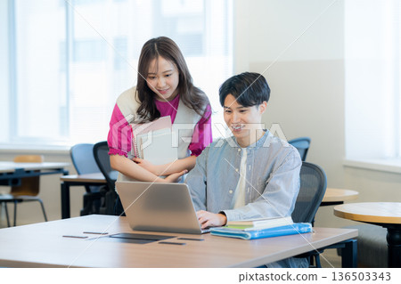 學生一邊看著電腦一邊交談 學生一邊看著電腦一邊交談 136503343