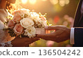 Hands holding a bouquet and a gift 136504242