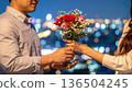 A man giving a bouquet and a woman receiving it 136504245