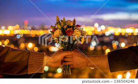 Handing over a bouquet of flowers over the night view 136504246