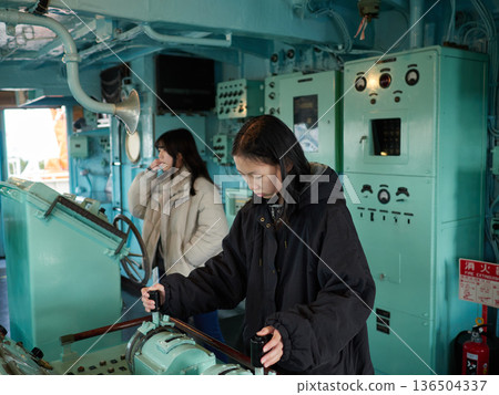 Two junior high school sisters playing in the cockpit of the Antarctic research vessel Fuji, a tourist spot at Nagoya Port in winter Two junior high school sisters playing in the cockpit of the Antarctic research vessel Fuji, a tourist spot at Nagoya Port in winter 136504337