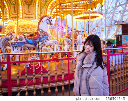 Beautiful illuminations at an amusement park at night and high school girls having fun 136504345