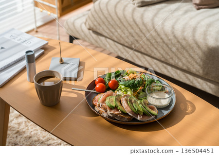 A sunny living room with a sofa and table where breakfast is served A sunny living room with a sofa and table where breakfast is served 136504451
