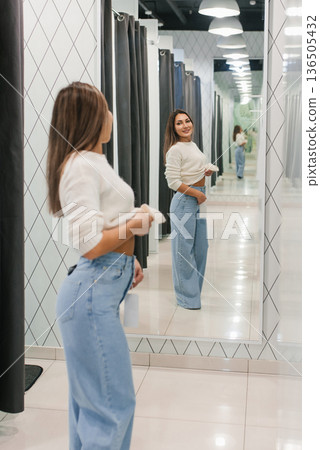 Woman Trying Jeans In Clothing Store Mirror 136505432