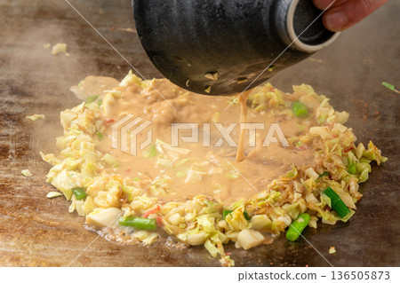 Monjayaki, a flour-based dish that is a downtown specialty and cooked on an iron plate 136505873