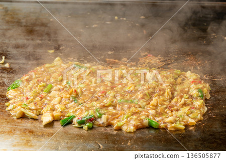 Monjayaki, a flour-based dish that is a downtown specialty and cooked on an iron plate Monjayaki, a flour-based dish that is a downtown specialty and cooked on an iron plate 136505877