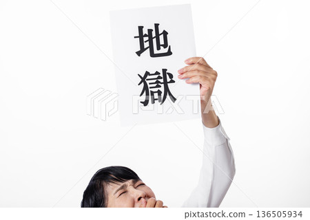 一位表情痛苦的老婦人舉著一張紙，上面寫著「地獄」。 136505934