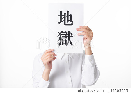 一個身穿白襯衫的人拿著一張紙，上面寫著「地獄」二字。 136505935