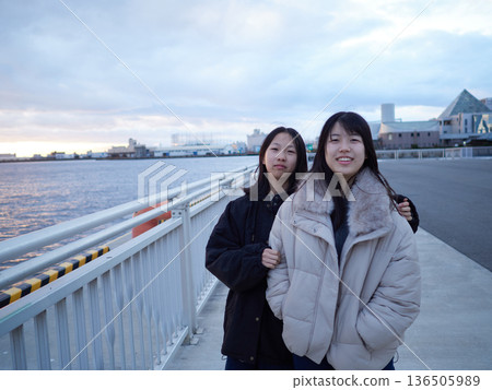 Two junior high school sisters playing on the bank of Nagoya Port in the evening during winter break Two junior high school sisters playing on the bank of Nagoya Port in the evening during winter break 136505989