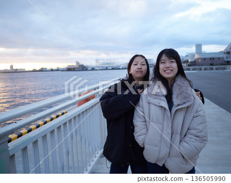Two junior high school sisters playing on the bank of Nagoya Port in the evening during winter break Two junior high school sisters playing on the bank of Nagoya Port in the evening during winter break 136505990