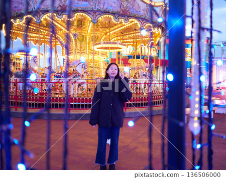 Beautiful illuminations at an amusement park at night and junior high school girls having fun 136506000