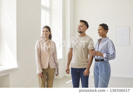 Real estate agent, realtor presenting young couple modern indoor space, professional consultation Real estate agent, realtor presenting young couple modern indoor space, professional consultation 136506017