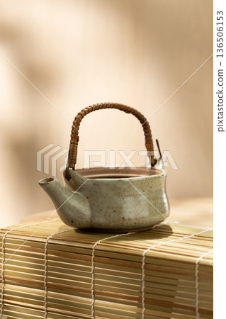 Japanese Ceramic Teapot on Bamboo Mat with Copy Space 136506153