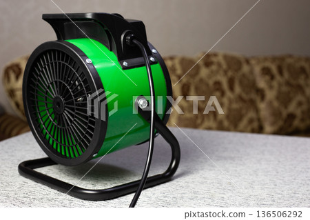 Fan powered heater heats room with stream of hot air. This helps warm the room and improves winter comfort. Solving your heating problem with portable heater. Indispensable device for home 136506292