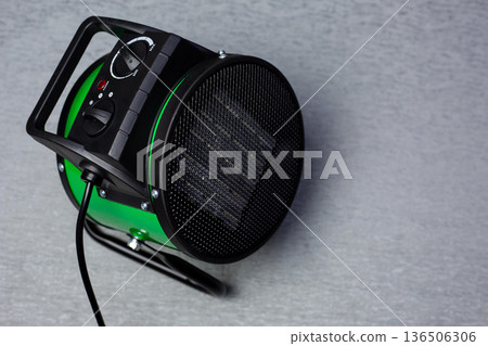 Heater for apartment, closeup. Electric ceramic fan heater on surface. Heat gun with fan for heating. Top view of heater with space for text. Concept for warming and raising temperature in room 136506306