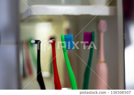 Close-up photo of blue bristles on green toothbrush. Brightly colored toothbrush in holder. Colorful children toothbrush to engage child. Toothbrushing concept, bathroom theme and morning routine Close-up photo of blue bristles on green toothbrush. Brightly colored toothbrush in holder. Colorful children toothbrush to engage child. Toothbrushing concept, bathroom theme and morning routine 136506507