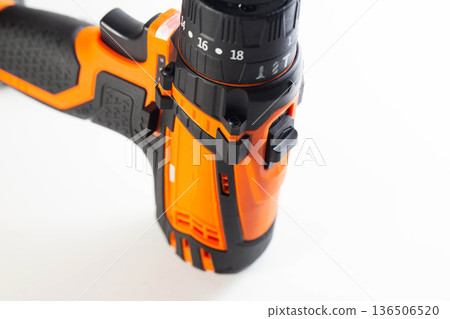 Close up view of electric cordless drill body. Focus on torque setting collar and forward reverse switch. Portable power tool for construction and home repair on white background. Close up view of electric cordless drill body. Focus on torque setting collar and forward reverse switch. Portable power tool for construction and home repair on white background. 136506520