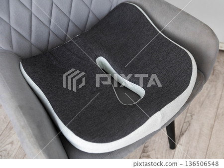 Ergonomic orthopedic seat cushion for posture correction and pressure relief, designed for back and pelvis support, presented on contemporary quilted chair. Ergonomic orthopedic seat cushion for posture correction and pressure relief, designed for back and pelvis support, presented on contemporary quilted chair. 136506548
