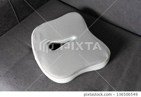 Ergonomic seat cushion with coccyx cutout design for spinal pressure relief, promoting posture improvement and comfort during prolonged sitting 136506549