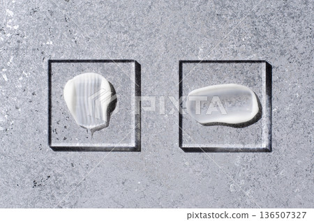 A sample of white body cosmetics on a glass square. Grey background. A sample of white body cosmetics on a glass square. Grey background. 136507327