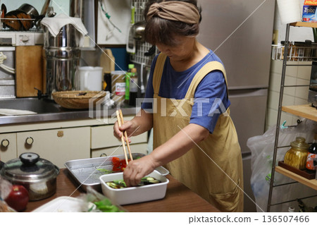 A woman making fried summer vegetables A woman making fried summer vegetables 136507466