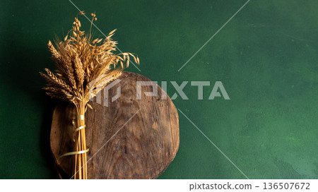 Wheat ears on a green background copy space. Dried Grasses on Wooden Board Wheat ears on a green background copy space. Dried Grasses on Wooden Board 136507672
