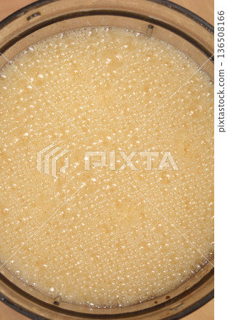 Foamy smoothie of mandarin, orange and banana in a blender Foamy smoothie of mandarin, orange and banana in a blender 136508166