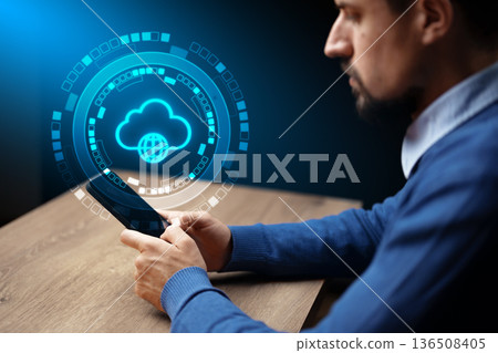 Man using smartphone with cloud technology concept displayed on screen during evening 136508405