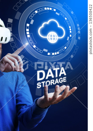 Man in virtual reality headset shows data storage concept in digital space with glowing cloud icon 136508422