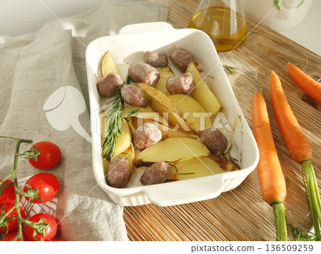 Baked potato wedges and homemade sausages made from farm-raised meat. Food and health. Spices and natural products. Baked potato wedges and homemade sausages made from farm-raised meat. Food and health. Spices and natural products. 136509259