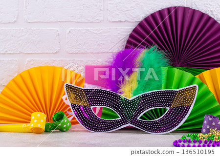Vibrant Mardi Gras background with mask, beads, and festive decorations Vibrant Mardi Gras background with mask, beads, and festive decorations 136510195