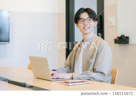 Man operating laptop at cafe 136511673