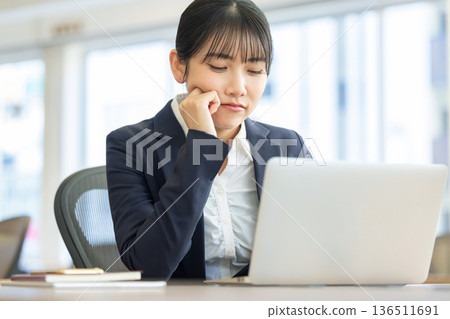 Worried woman looking at computer screen 136511691