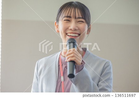 年輕女子拿著麥克風說話 136511697
