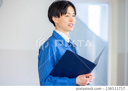 Young engineer in blue work clothes Young engineer in blue work clothes 136511717