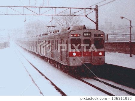 The Tokyu Denentoshi Line 8500 rapid train bound for Nagatsuta passes through Tana Station during heavy snowfall in the Tokyo metropolitan area. 136511953