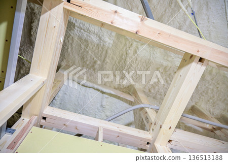 Image of a house: Spray insulation on a wooden single-story house under construction 136513188