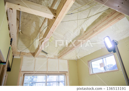 Image of a house: Spray insulation on a wooden single-story house under construction 136513191