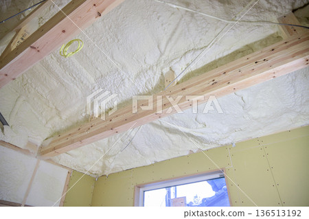 Image of a house: Spray insulation on a wooden single-story house under construction 136513192