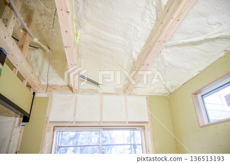 Image of a house: Spray insulation on a wooden single-story house under construction 136513193
