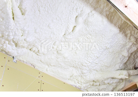 Image of a house: Spray insulation on a wooden single-story house under construction Image of a house: Spray insulation on a wooden single-story house under construction 136513197