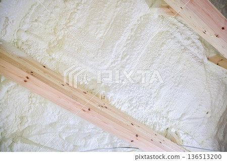 Image of a house: Spray insulation on a wooden single-story house under construction Image of a house: Spray insulation on a wooden single-story house under construction 136513200