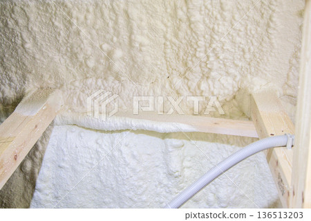 Image of a house: Spray insulation on a wooden single-story house under construction Image of a house: Spray insulation on a wooden single-story house under construction 136513203