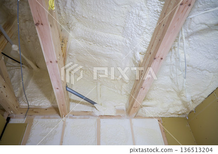 Image of a house: Spray insulation on a wooden single-story house under construction 136513204