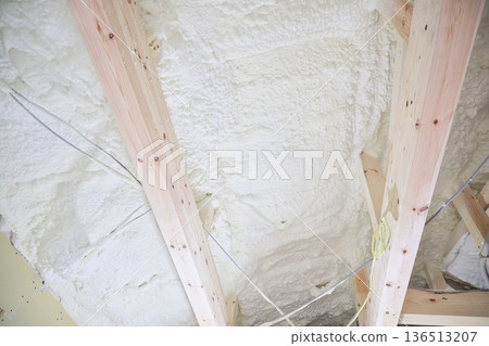 Image of a house: Spray insulation on a wooden single-story house under construction Image of a house: Spray insulation on a wooden single-story house under construction 136513207