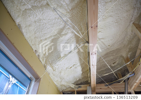 Image of a house: Spray insulation on a wooden single-story house under construction Image of a house: Spray insulation on a wooden single-story house under construction 136513209