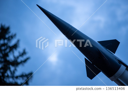 Missile rocket silhouette against cloudy blue sky Missile rocket silhouette against cloudy blue sky 136513406