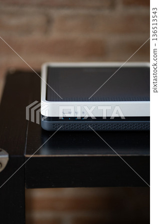 Wireless router modem with active blue indicator lights providing fast internet connection and secure network, sitting on a dark wooden surface in a home or office setting Wireless router modem with active blue indicator lights providing fast internet connection and secure network, sitting on a dark wooden surface in a home or office setting 136513543