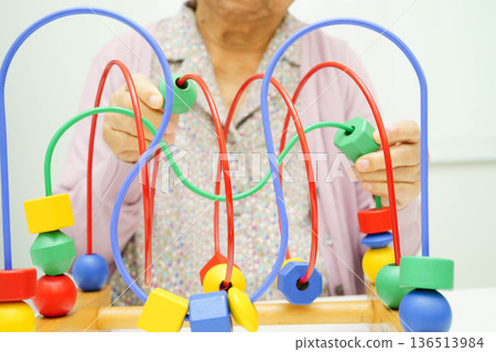 Asian elderly woman playing enhancing skill board game. Asian elderly woman playing enhancing skill board game. 136513984